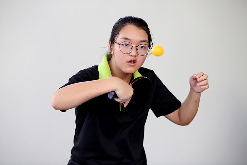 A teenage girl is enjoying playing 'ping pong' (table tennis) as part of her healthy lifestyle regime.