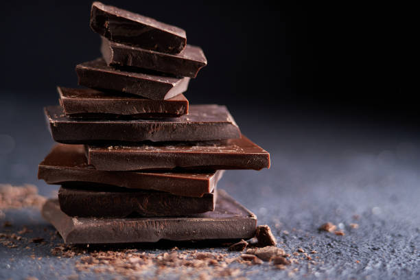 istock Piece of dark chocolate and chocolate chips on a dark background 1209628380