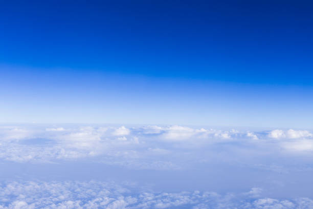 istock clear blue sky background with white beautiful clouds. View from the window airplane. Travel concept 1209628977