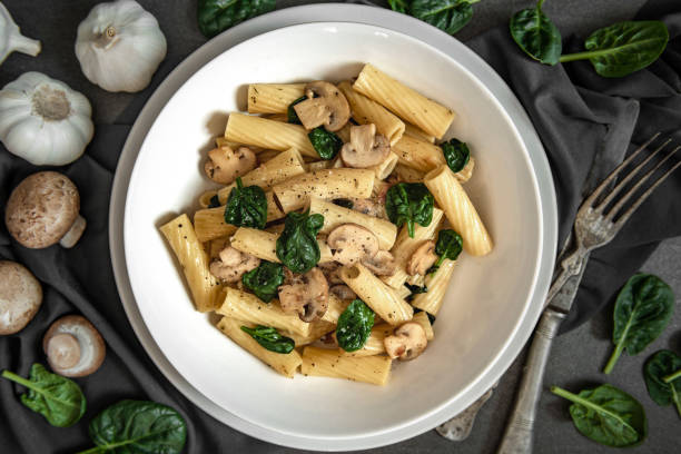 Spinach and mushrooms pasta Healthy vegan spinach and mushrooms pasta spinach pasta stock pictures, royalty-free photos & images