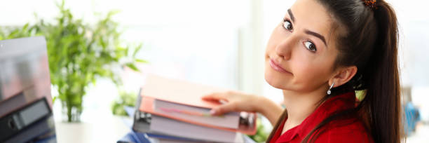 istock Young woman sitting in office with heap of documents and feeling stressed 1209630014