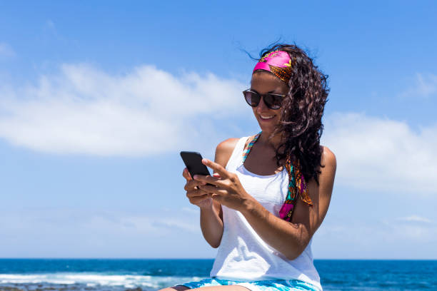 istock young beautiful happy woman using mobile phone over clear blue background. Summer. Lifestyle 1209631137