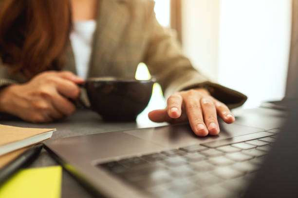 istock Businesswoman using and touching on laptop touchpad while drinking coffee 1209631897