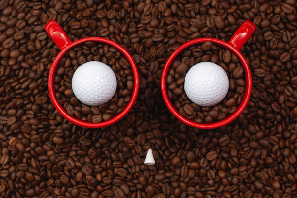 Two red cups full of coffee beans and one golf ball.