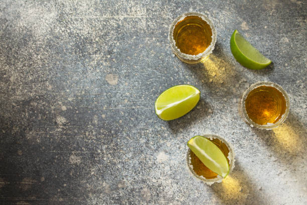 istock Gold Tequila. Mexican Gold Tequila shot with lime and salt on a stone light concrete worktop. Top view flat lay background. Copy space. 1209636890