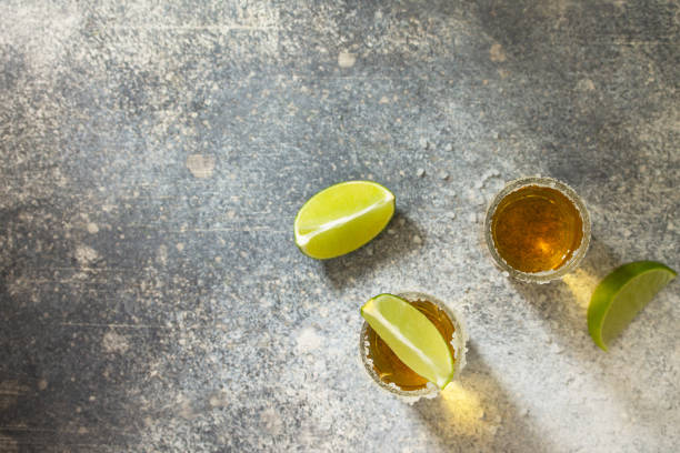 istock Gold Tequila. Mexican Gold Tequila shot with lime and salt on a stone light concrete worktop. Top view flat lay background. Copy space. 1209636892
