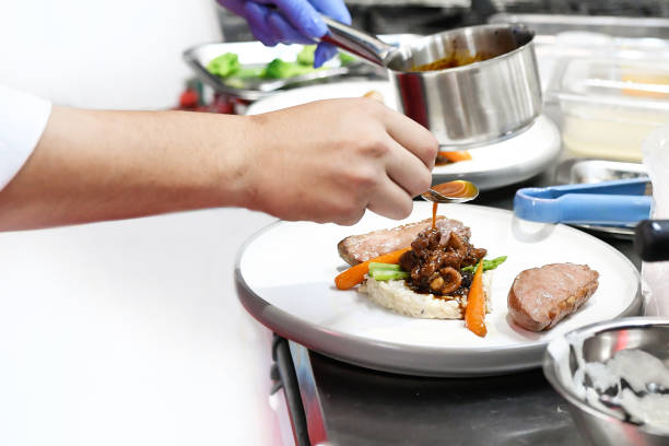 istock Chef cooking, Chef preparing food in the kitchen, Chef decorating dish, closeup 1209637373