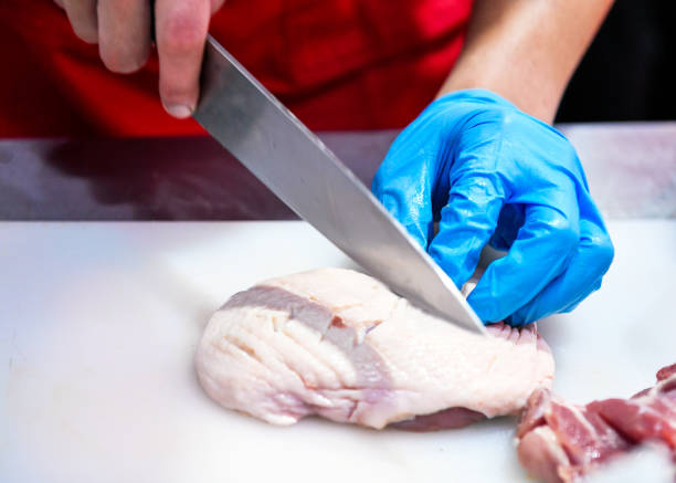 istock Chef cutting chicken meat on kitchen, Chef preparing food, cutting meat 1209637380