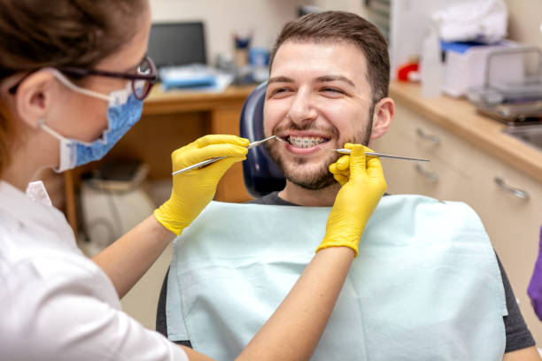 istock Man at the dentist braces check up 1209638136