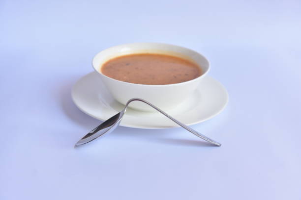 inclined metal spoon next to the white soup bowl, lack of function