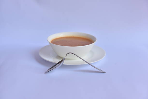 inclined metal spoon next to the white soup bowl, lack of function