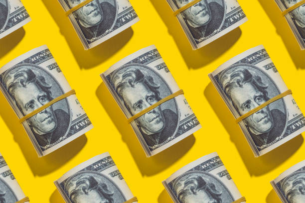 istock American dollar rolls flat lay on yellow background 1209641624