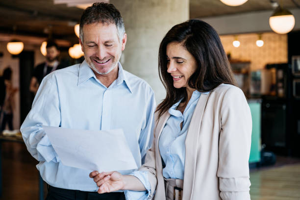 istock Mature business colleagues discussing document in office 1209643269