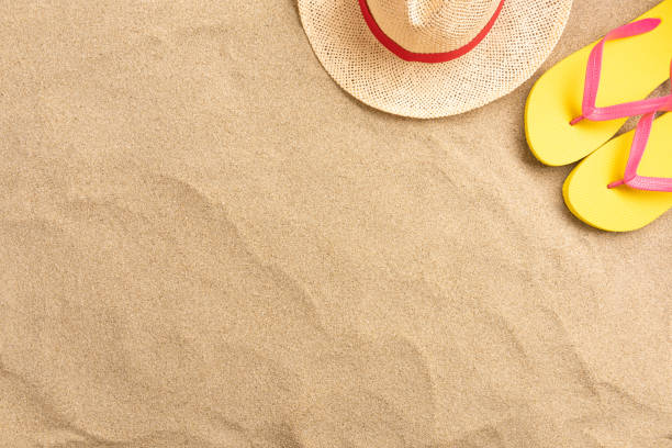 istock Flip flops, straw hat, on sand background. Beach vacation concept .Top view with copy space. 1209644595