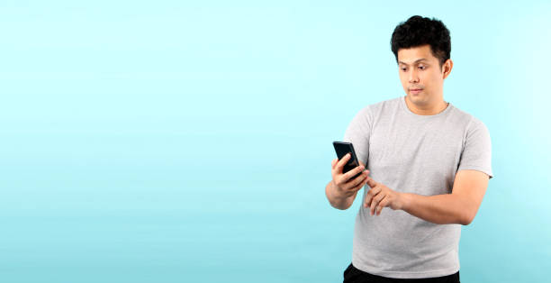 istock Portrait of handsome Asian man being Shock and surprised after reading message from smarrtphone, isolated on blue background in studio With copy space. 1209646821