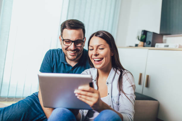istock Happy young couple enjoying time online on digital tablet. 1209648228