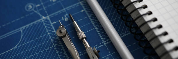 istock Pair of compasses and white pencil lying over blueprint paper 1209653909