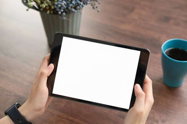 istock Close-up of hand holding black tablet and coffee on table office. 1209657891