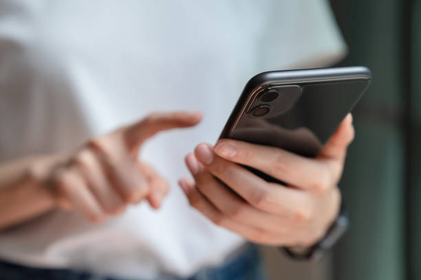 istock woman holding and using smartphone typing sms message at social network. 1209657931