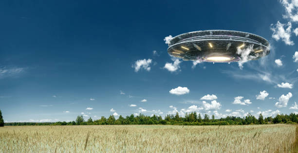 istock UFO, an alien plate hovering over the field, hovering motionless in the air. Unidentified flying object, alien invasion, extraterrestrial life, space travel, humanoid spaceship. mixed medium 1209658070