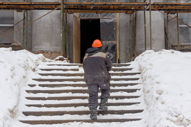 istock A builder in an orange helmet climbs the stairs to a construction site. 1209658125