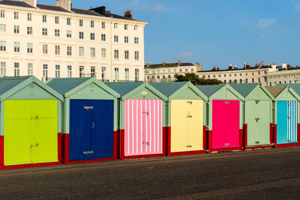 Brightly coloured beach huts on the promenade at Hove Brightly coloured beach huts line much of the promenade in Hove, part of the city of Brighton and Hove, on England’s south coast.  These small, wooden, structures are used by residents to store beach equipment, and to provide a base when enjoying the sea. Hove stock pictures, royalty-free photos & images