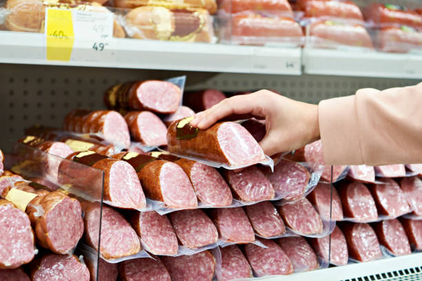 istock Smoked sausage in hands at store 1209661785