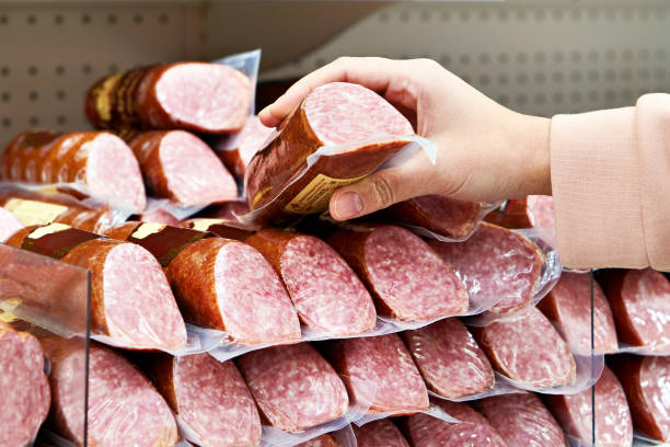 istock Smoked sausage in hands at store 1209661812