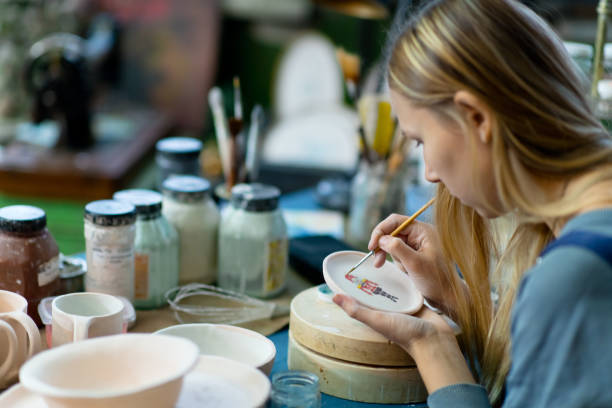 istock Young woman painting on ceramics 1209663600