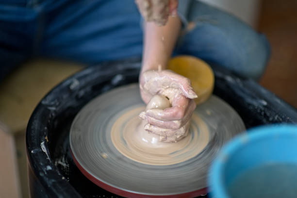 Young female artist making handmade ceramics on pottery wheel