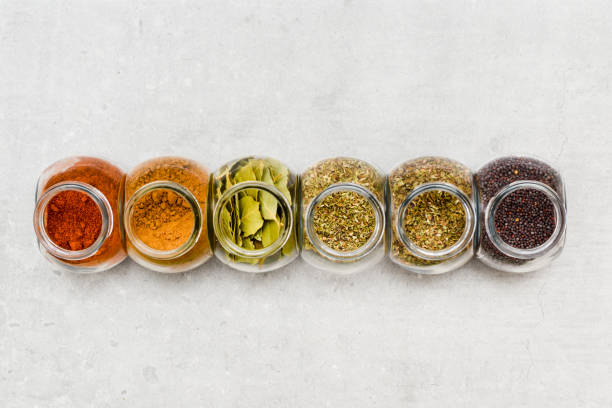 A selection of herbs and spices for adding flavour to food when cooking on a kitchen worktop at high angle A selection of herbs and spices for adding flavour to food when cooking on a kitchen worktop at high angle spice rack stock pictures, royalty-free photos & images