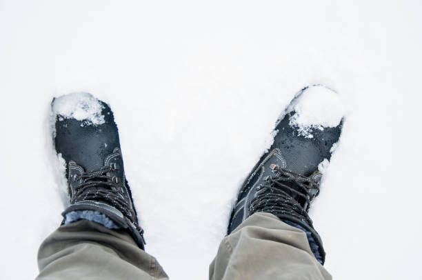 istock Black boots on covered with snow. Work shoes 1209667380