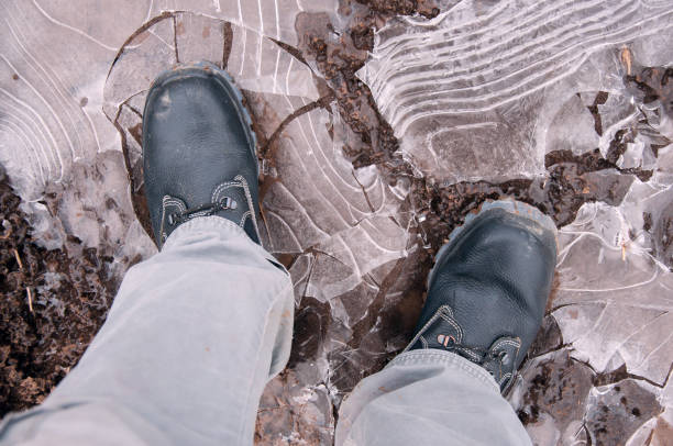 istock Work boots on a background of frozen ground. Work shoes 1209667505