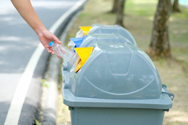 istock Hand put plastic bottle to the gray bin in park or garden with day light 1209669119