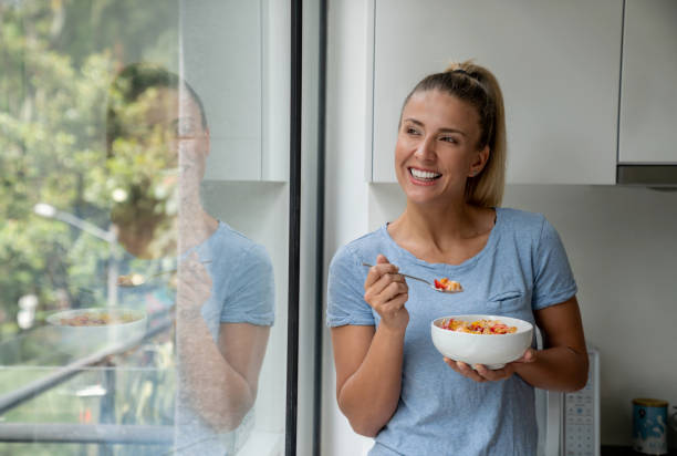 istock Happy woman eating breakfast at home 1209669549