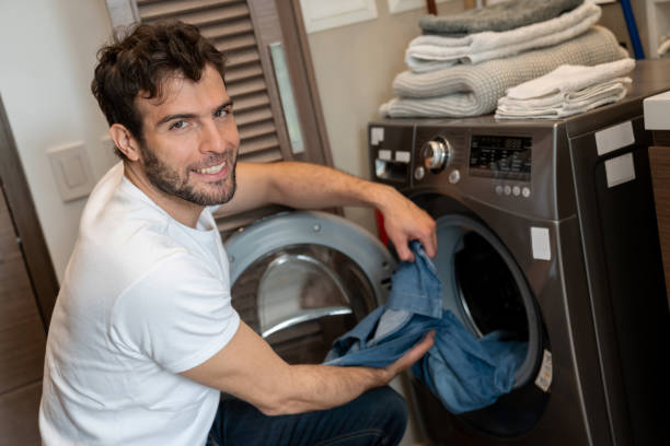istock Happy man at home doing the laundry 1209669605