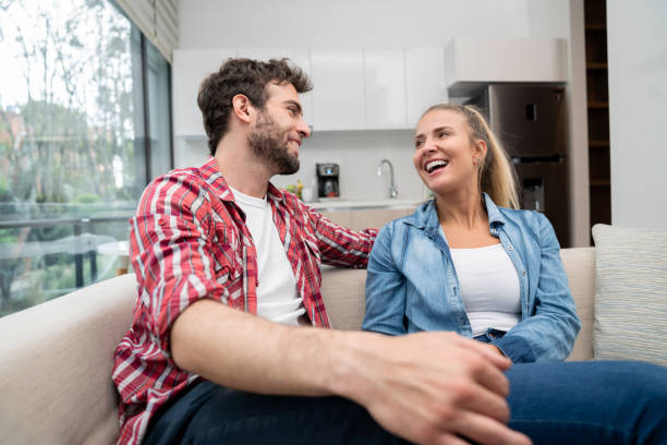 istock Loving couple looking very happy talking at home 1209669657