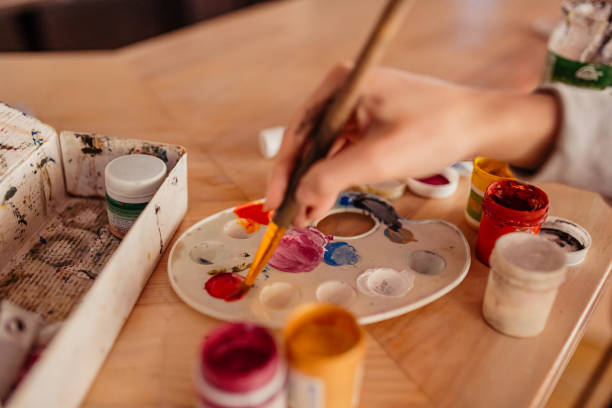 istock Artist paint brushes and palette on wooden background 1209670331