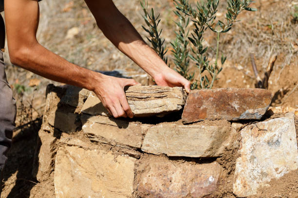 istock Close-up of construction worker builds stone wall 1209671089
