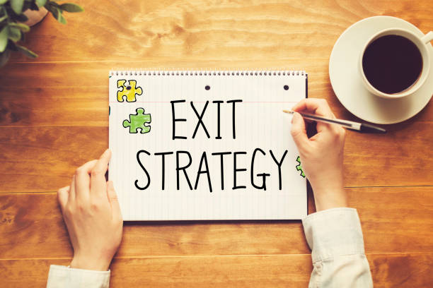 Exit Strategy text with a person holding a pen stock photo