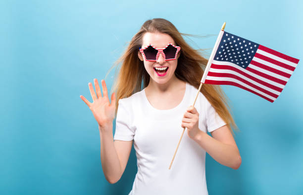 istock Happy young woman holding an American flag 1209672421