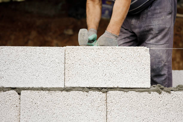 istock Close-up of construction worker builds brick wall 1209677288
