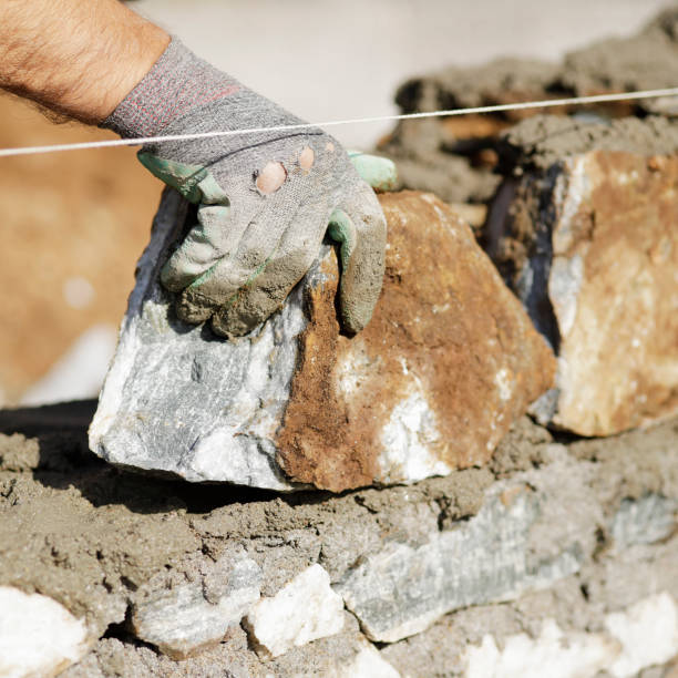 Close-up of construction worker builds stone wall