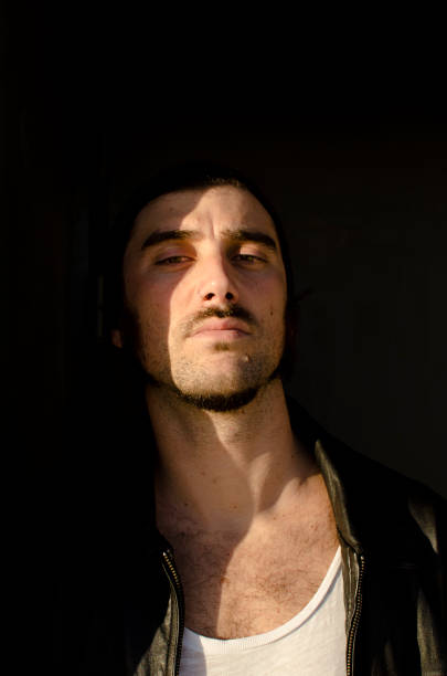 istock man with a goatee is in the shadows with a solemn look 1209677619
