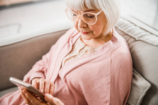 istock Elderly woman in glasses using modern smartphone 1209678363