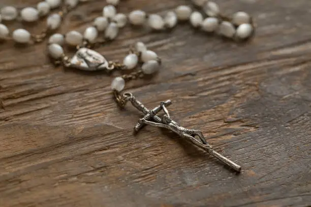 Photo of Catholic rosary at an old wooden table