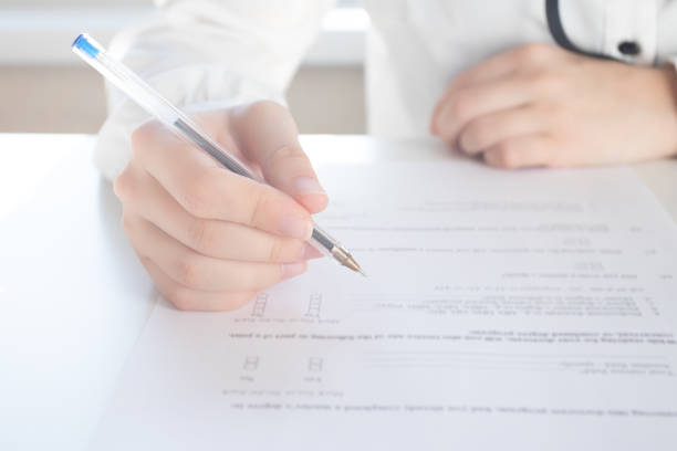 istock Filling the test. Hands hold a pen over paper 1209681627