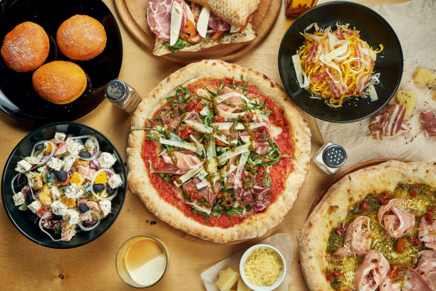 istock Assorted different dishes on wooden background. Dining table with pizza, pasta, dessert, donuts, salad. Italian food. Top view, food flat lay 1209684461
