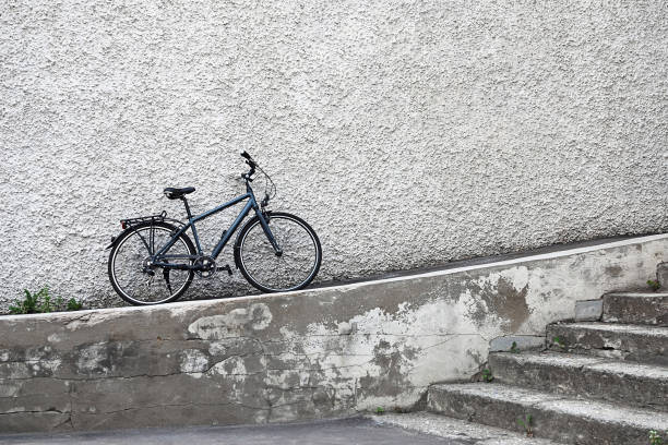 Single bicycle leaned against stone wall, real cityscape