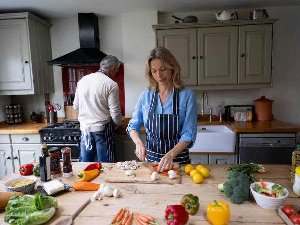 istock Happy couple in the kitchen cooking dinner together 1209687489